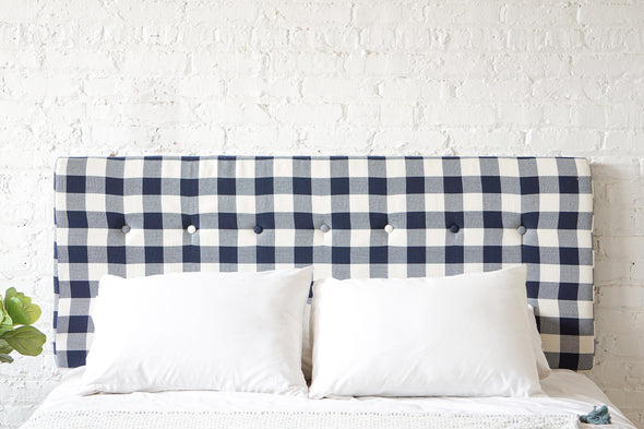 Cushioned, tufted headboard in a navy blue gingham fabric with covered buttons. Hand sewn and made in the USA. Nautical, coastal design.
